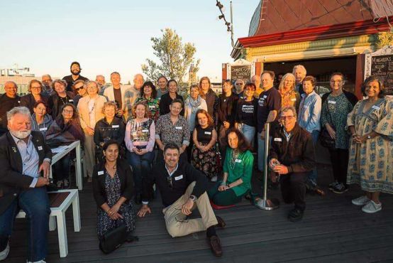 A group of people posing for camera at a rooftop restaurant