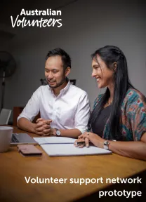 The cover page of the linked document. It includes the Australian Volunteers logo, and the title of the document: 'Volunteer support network prototype'. The background image is of two staff members sitting at a table looking at a laptop, with a notebook open on the table.