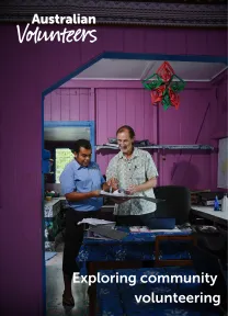 The cover page of the linked document. It includes the Australian Volunteers logo, and the title of the document: 'Exploring community volunteering'. The background image is of two men reviewing documents in a binder.