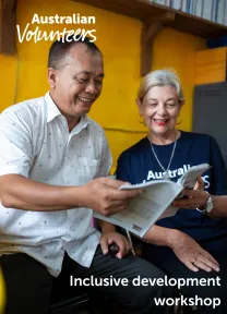 The cover page of the linked document. It includes the Australian Volunteers logo, and the title of the document: 'Inclusive development workshop'. The background image is of two people holding a book open between them.