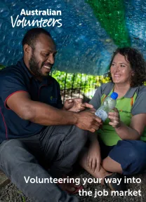 The cover page of the linked document. It includes the Australian Volunteers logo, and the title of the document: 'Volunteering your way into the job market'. The background image is of two people inspecting a recycled plastic water bottle together, while sitting in a tunnel created from plastic waste.