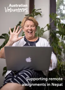 The cover page of the linked document. It includes the Australian Volunteers logo, and the title of the document: 'Supporting remote assignments in Nepal'. The background image is of a woman wearing earphones with a laptop on her lap. She is waving and smiling at the screen.